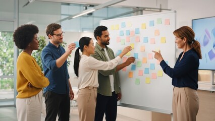 Obraz premium Diverse Business Team Brainstorming with Sticky Notes on Whiteboard