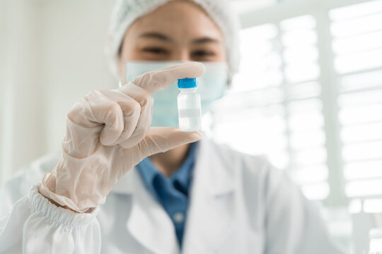 Female Laboratory Scientist Analyzing Samples with Pipette, Microscope and Laptop in Modern Research Laboratory