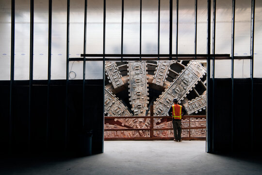 A construction white worker inspects a tunnel boring machine