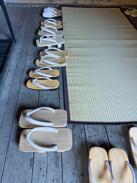 Traditional Japanese wooden sandals lining tatami mat entrance