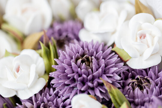 Floristry from Zephyr. Close-up of purple and white artificial flowers arranged together, showcasing intricate details of petals and leaves in a vibrant floral display