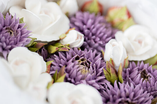 Floristry from Zephyr. Arrangement of white roses and purple asters in a floral bouquet, showcasing vibrant colors and intricate petal details against a soft background