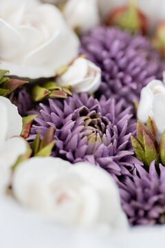 Floristry from Zephyr. Close-up of white roses and purple flowers arranged together, showcasing intricate petal details and vibrant colors in a floral composition