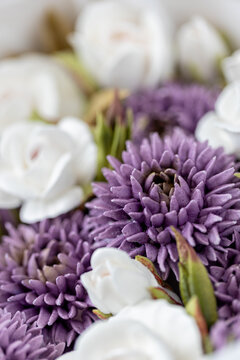 Floristry from Zephyr. Purple and white flowers arranged together in a close-up view, showcasing intricate petal details and vibrant colors in a floral composition