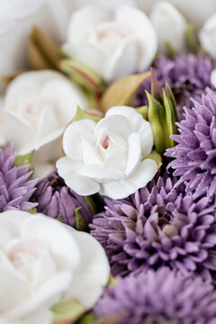 Floristry from Zephyr. White and purple artificial flowers arranged together in a decorative display, showcasing intricate details and textures of petals and leaves