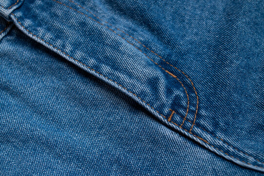 Blue jean pocket stitching creates textile detail across frame, with woven cotton surface visible in macro focus. Denim texture fits clothing promotion, craft content, fashion layouts, use.