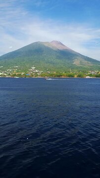 Footage captured from a boat showing Mount Gamalama, an active volcano rising prominently on Ternate Island, North Maluku, Indonesia.