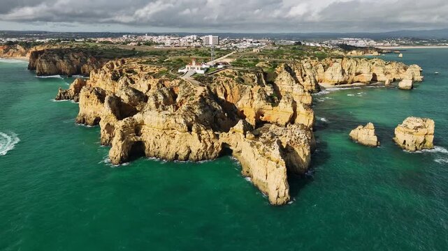 Drone view of Ponte da Piedade in Lagos, Algarve, Portugal, with sea stacks, rocky coves and coastal cliffs, ocean water. Orbit parallax shot.