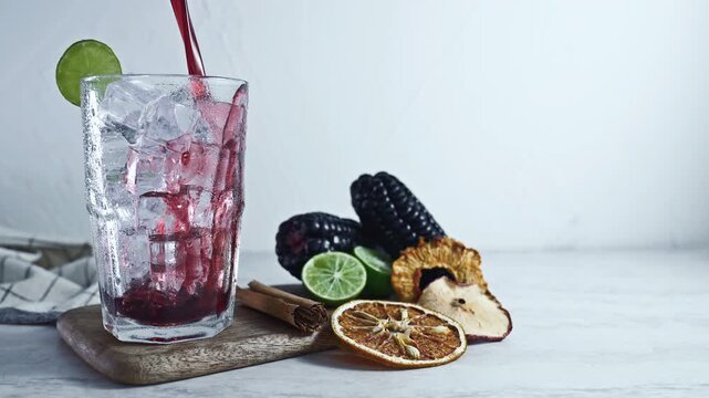 Pouring Peruvian Chicha Morada, Purple Corn Drink with Lime and Cinnamon