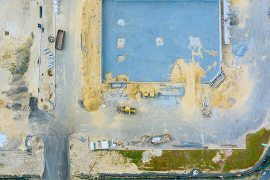 Workers machinery are active on site of new building in city, ongoing construction efforts.