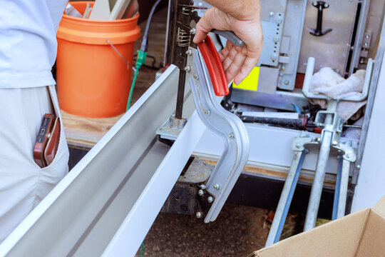 Builder is cutting hole tool to gutter metal parts inside work truck