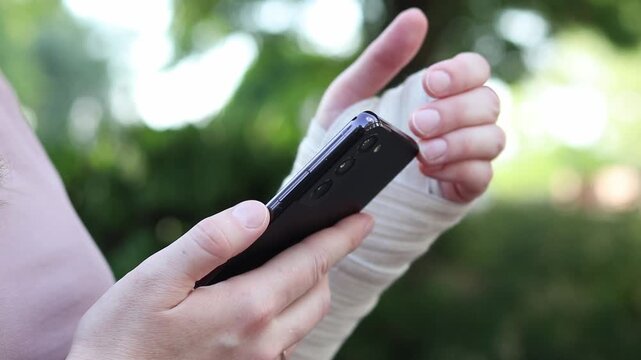 Close-up of a female hand tightly bandaged with a medical elastic bandage to fix the joint after a sprain, dislocation or fracture of the bones of the limb. Concept of first aid, treatment of injuries