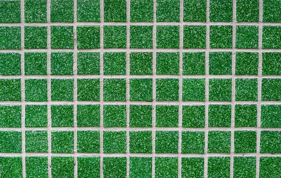 Full frame background texture of sharp emerald green glass mosaic tile grid pattern with white grout lines