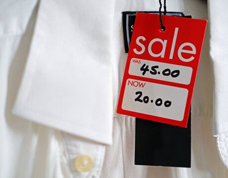 For sale tag hanging from a traditional, formal white shirt. Rag trade, 'Fast fashion' and retail discounting and cloths stock clearance
