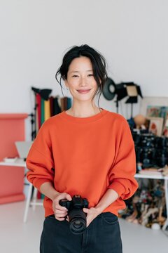 Female portrait photographer holding a dslr camera in a bright studio setting for portrait background and banner use