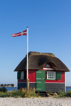 Traditional red and green wooden beach hut at Eriks Hale on Aeroe island.