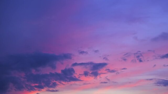 Morning or evening sky. Colorful clouds fill twilight with gradients of purple and pink during sunset or sunrise. Natural background. Beauty in nature. Expressive cloudscape. High quality 4K footage.