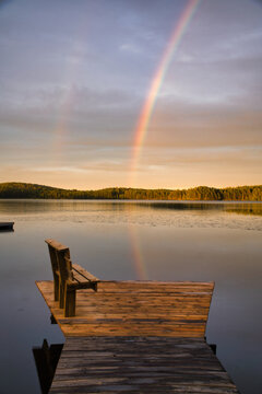 Wooden Pier with Bench at Lake Under Double Rainbow