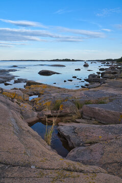 Rocky Skerry Coast by Calm Sea Under Blue Evening Sky