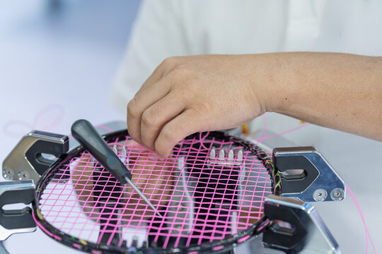 professional staff stringing badminton rackets at work