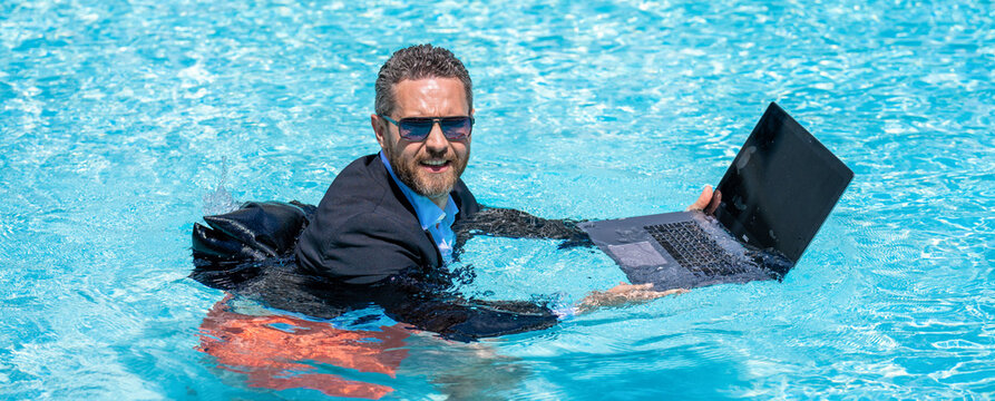 Crazy business man summer vacation. Remote working. Summer business vacation. Funny crazy businessman rest in formal wear in pool. Businessman in suit with laptop in swimming pool. Laptop meeting