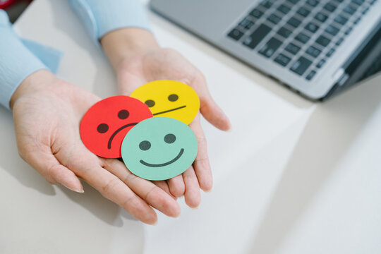 Customer service satisfaction survey feedback rating emotion mood hand holding colorful circle sign representing joy and sadness