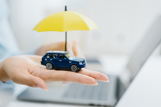 Blue car model protection insurance umbrella hand security safety vehicle coverage finance
