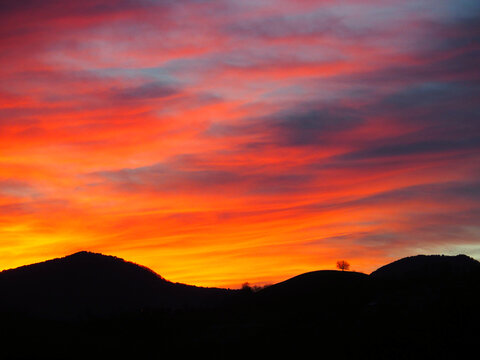 Fiery sunset sky over mountain silhouette