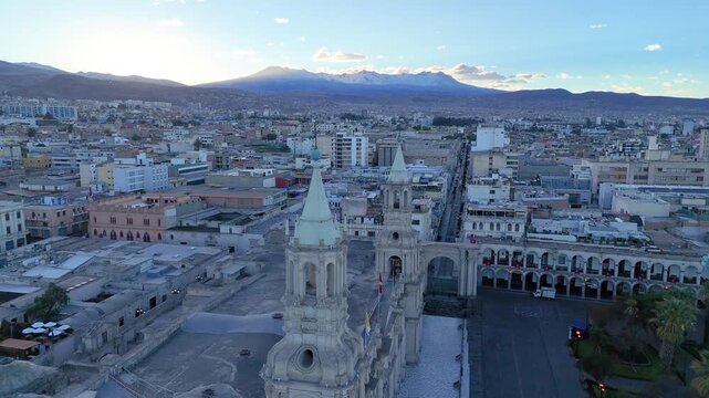 Side aerial view of Arequipa Cathedral with Pichu Pichu volcano in the background at sunrise, Peru
