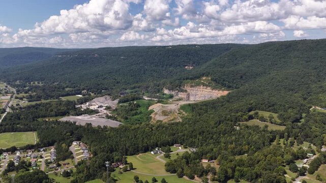 Aerial of forested canyon and agricultural fields in Dunlap Tennesseee with exposed rock cliffs and gravel processing areas