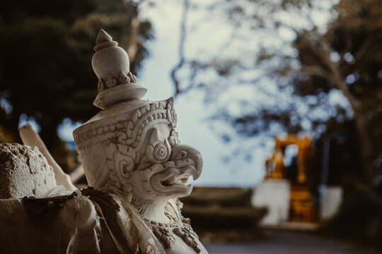 Close-up of a traditional white marble Garuda sculpture at a sacred Buddhist temple site