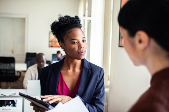 Businesswomen discussing project in modern office