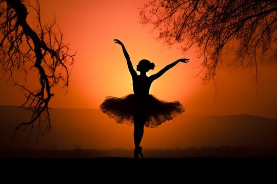 Ballerina silhouette dancing in a romantic pose against a vibrant orange sunset backdrop