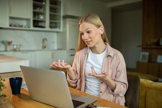Woman on video call with laptop in home kitchen