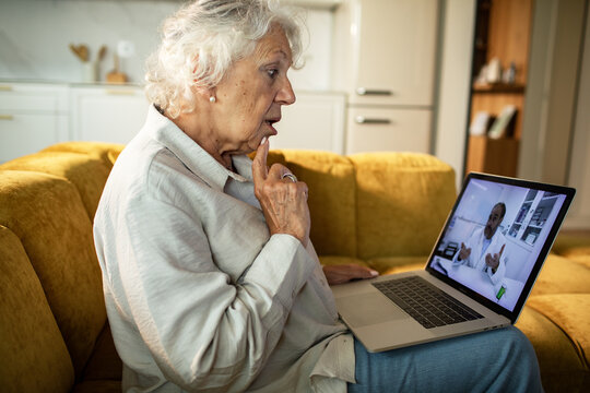 Senior woman having telehealth video consultation with doctor at home
