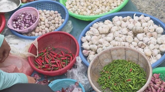 Vendor selling garlic and chili at local traditional market, daily life in Vietnam
