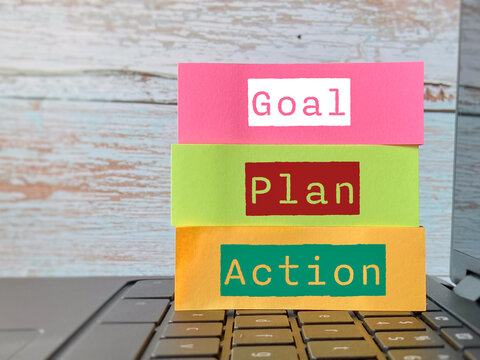 Colorful sticky notes reading Goal, Plan and Action arranged on a laptop, illustrating strategic planning, productivity, motivation and achievement.