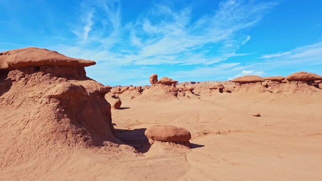 Unique mushroom-shaped sandstone hoodoos stand across the rugged desert badlands of Goblin Valley State Park in Utah