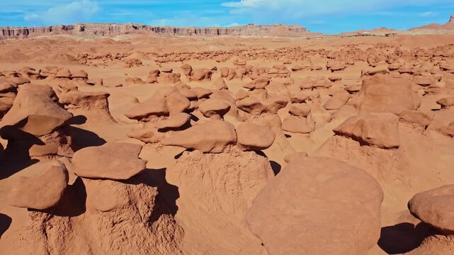 Unique mushroom-shaped sandstone hoodoos stand across the rugged desert badlands of Goblin Valley State Park in Utah