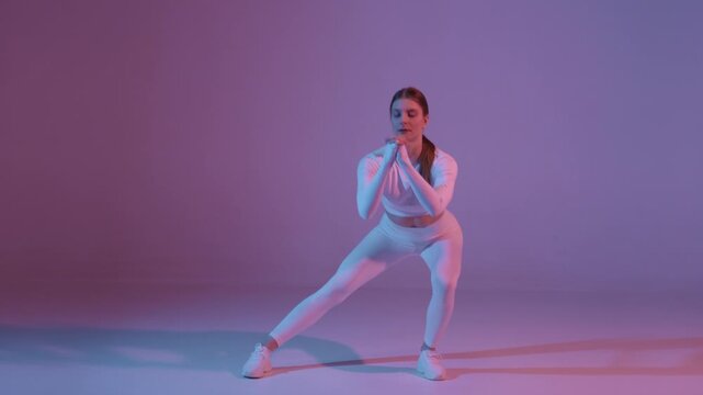 Female athlete in boxing guard pose under colored studio lights
