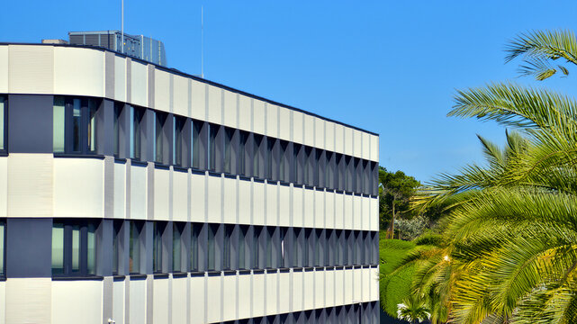Sustainable glass office building with trees for reducing carbon dioxide. Eco-friendly building in modern city. Office with green environment. Corporate building reduce CO2.