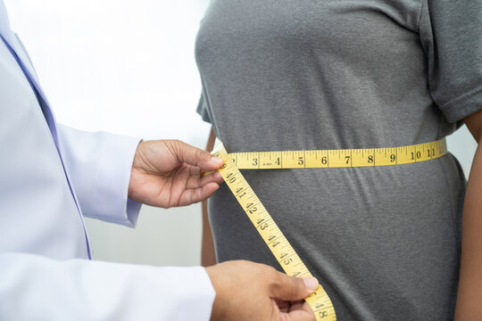 Asian woman with fat belly big size overweight and obesity with measure tape.