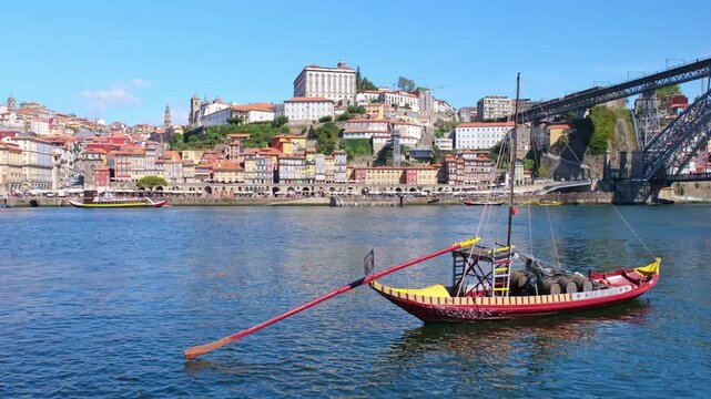 Rabelo boat framed by Porto Ribeira, Portugal, on the Douro River with traditional wooden deck and Vila Nova de Gaia waterfront