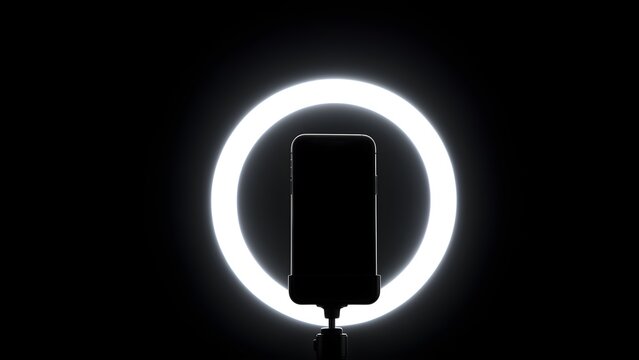 Ring light glowing in a dark room with phone mount, creator night shoot