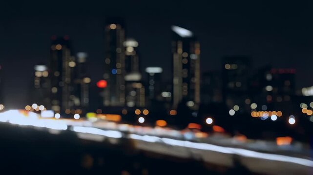 Intentionally blurred night city traffic streams along a roadway beneath an illuminated urban skyline. Urban lifestyle advertising, transportation campaigns, and city tourism promotion.