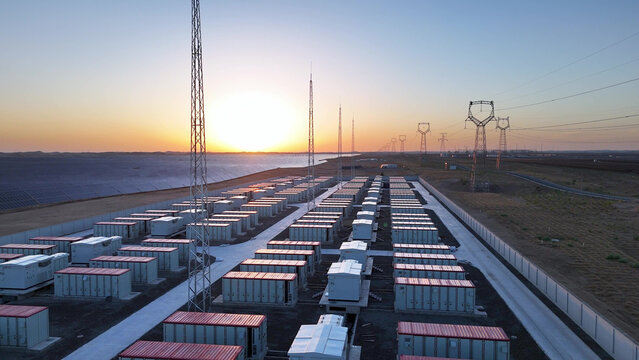 rows of battery storage containers at power station during sunset