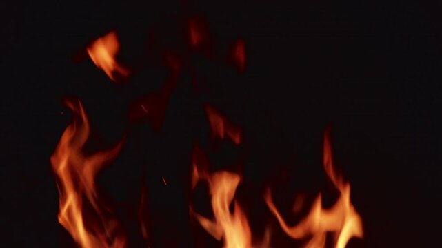 Flames dance in the dark while creating light and heat at a fire pit on a cool evening in an outdoor setting