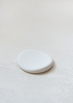 White round flat stone product display podium with generous copy space above for cosmetic product placement and beauty advertising.