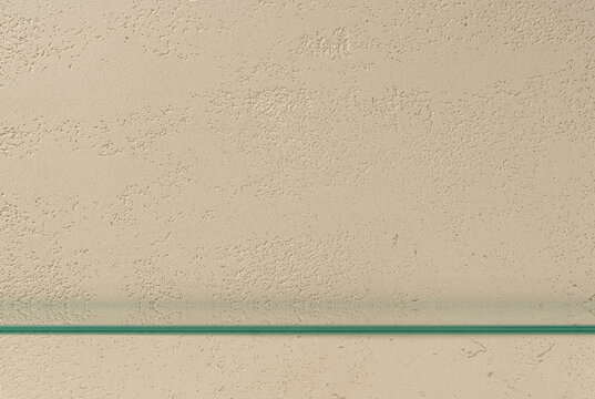 Wide Product Display Template made with Empty Glass Shelf on Travertine Textured Beige Wall