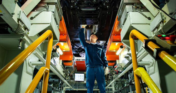 Auto Worker Inspecting Car Chassis